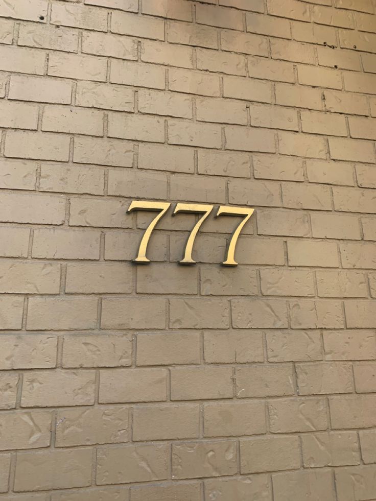 the number 777 on a brick wall