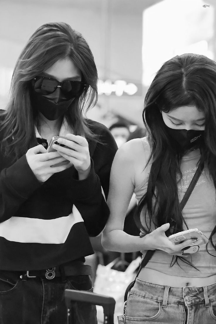 two young women looking at their cell phones