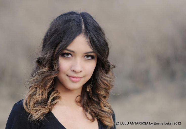 a beautiful young woman with long hair posing for a photo