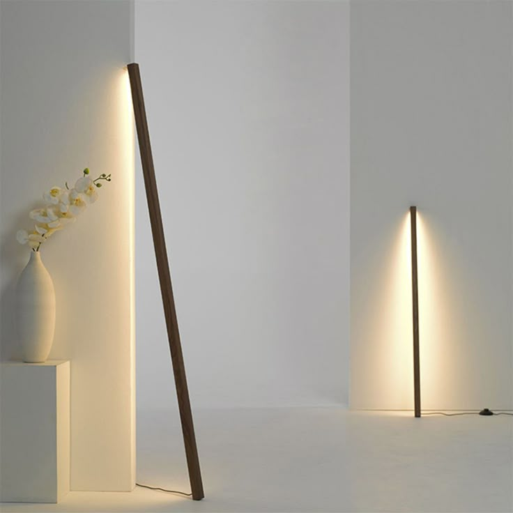 two tall white vases sitting next to each other on top of a floor lamp