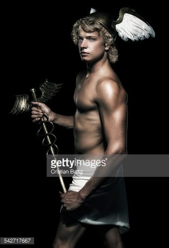 a shirtless man with angel wings holding a staff in his hand and looking at the camera