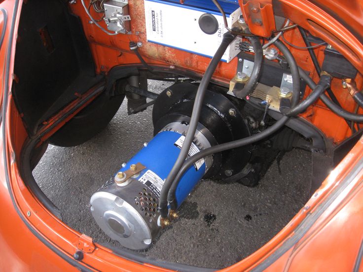 the inside of an orange car with its engine hooked up to it's pump