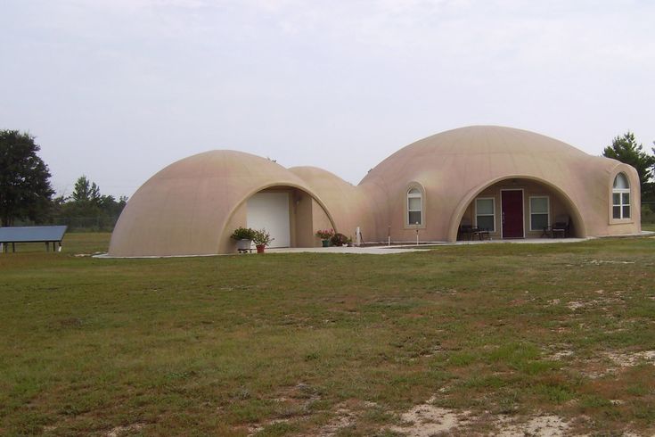 two round houses in the middle of a field