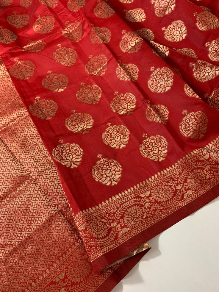 Red Banarasi semi silk saree with antique gold woven zari buttas and border. Saree length is 5.5m.  Saree edging is done. Can be purchased with the paired red aariwork embroidered silk blouse in Sz-34, 36 as in picture  OR just the as Saree Only by choosing in Options. With this saree ensemble you are ready to flaunt your saree immediately in your next party, temple visit, wedding function or at any special occasion  * Disclaimer: The colours might have slight variations due to digital photograp Gold Pre-draped Saree With Traditional Patterns For Festivals, Festive Red Banarasi Silk Anarkali Set, Gold Pre-draped Saree With Traditional Patterns For Puja, Red Tussar Silk Anarkali Set For Navratri, Red Banarasi Silk Anarkali Set For Festive Occasions, Red Zari Weaving Dupatta For Festive Occasions, Festive Red Dupatta With Zari Weaving, Traditional Gold Anarkali Set In Art Silk, Red Anarkali Set With Zari Work In Tussar Silk