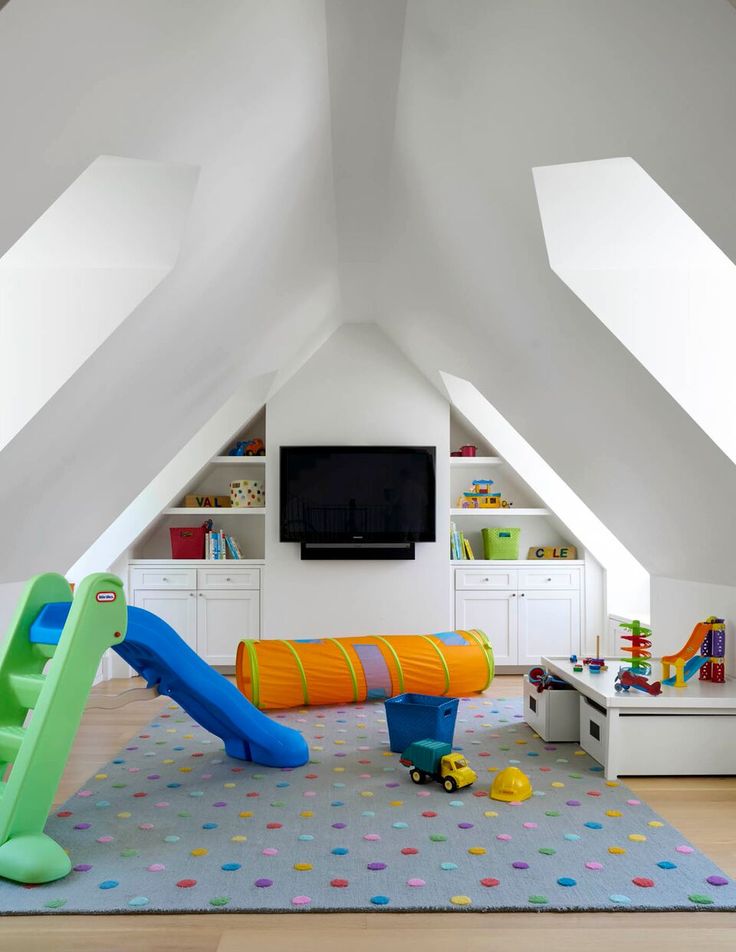 a child's playroom with toys and bookshelves in an attic space