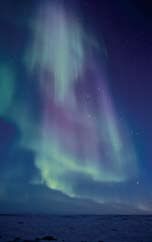 an aurora bore in the night sky over water