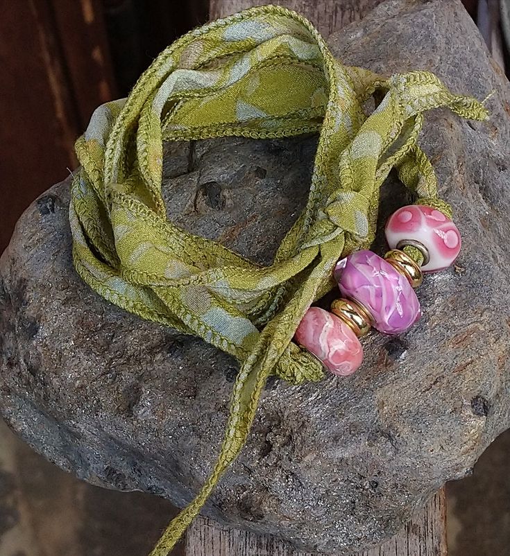 Unique Bracelet/Necklace made with High Quality Lampwork Beads, a beautiful Rhodochrosite Bead and a Ribbon made of Original Indian Sari Silk It can be used either as a Bracelet or a Necklece to be knotted Beads and Ribbon can be used separately at your convenience Green Hand Wrapped Beads For Jewelry Making, Green Wrap Bracelet With Round Beads For Festival, Green Multi-strand Wrap Bracelet As Gift, Adjustable Green Beaded Necklaces Hand Wrapped, Adjustable Green Hand-wrapped Beaded Necklaces, Green Hand-wrapped Beaded Necklaces As Gift, Adjustable Green Hand Wrapped Beaded Necklaces, Handmade Green Wrap Bracelet For Friendship, Green Handmade Wrap Bracelet For Friendship