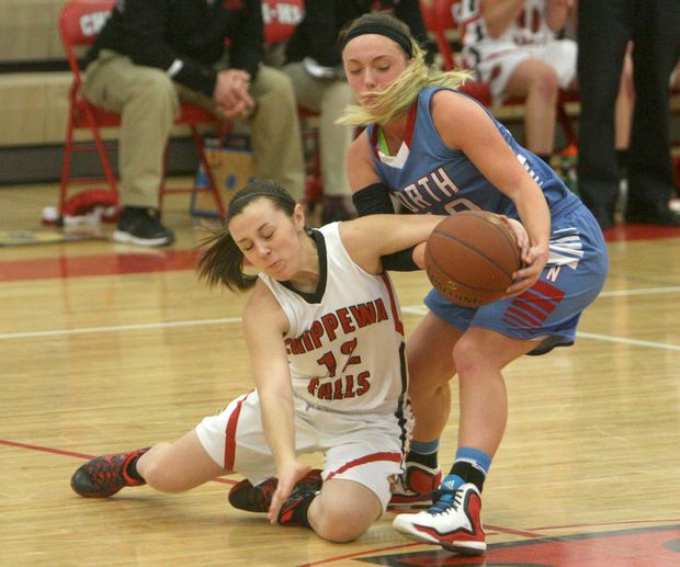 two girls are playing basketball on the court