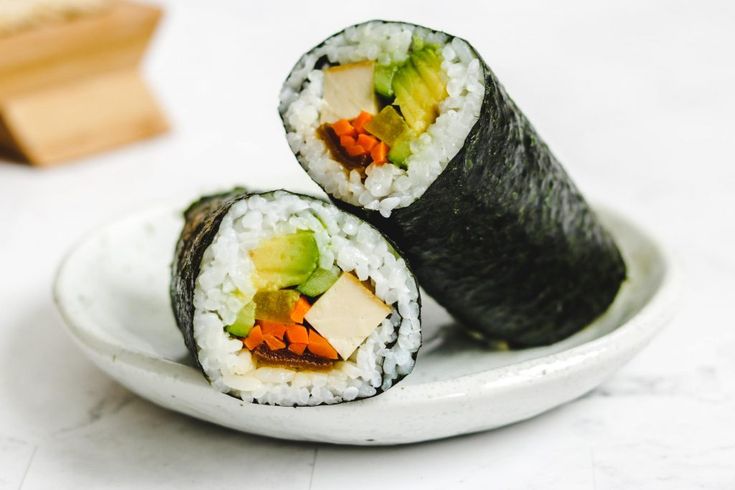 two pieces of sushi on a white plate