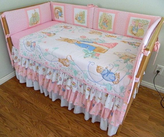 a baby crib with winnie the pooh bedding and pink trimmings