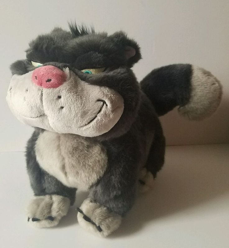 a stuffed animal that looks like an angry looking cat with pink nose and green eyes