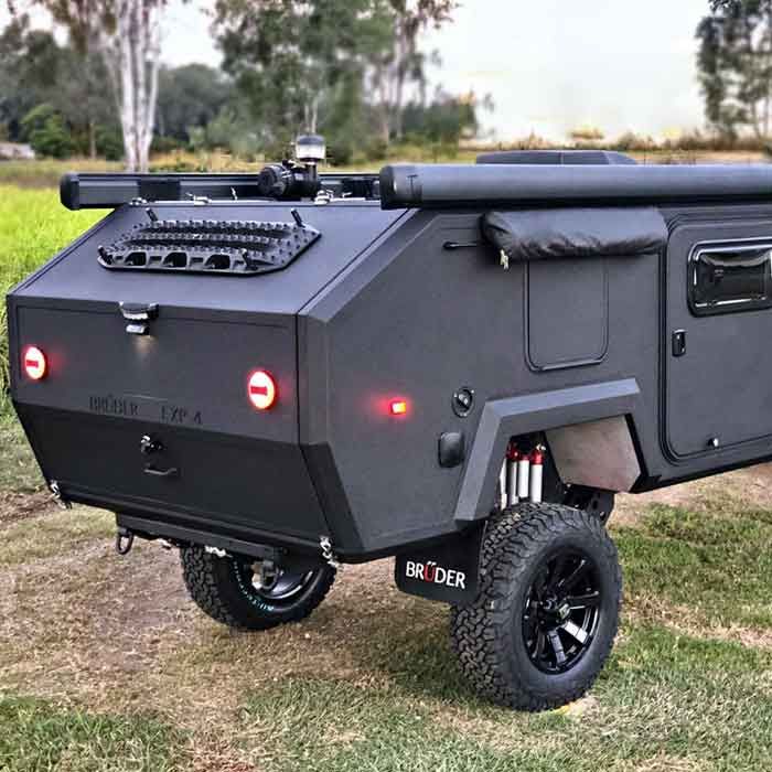 an off road camper trailer parked next to a pickup truck