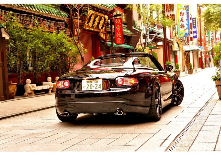 a black sports car is parked on the street