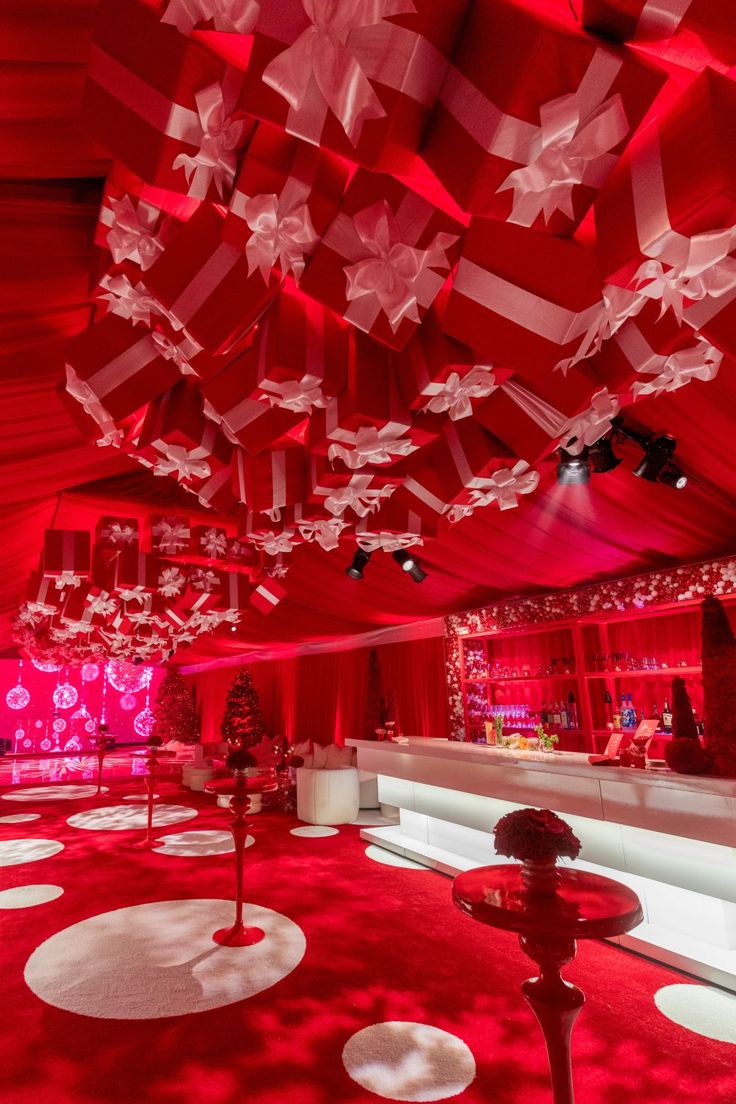 the interior of a red and white room with lots of lights hanging from the ceiling