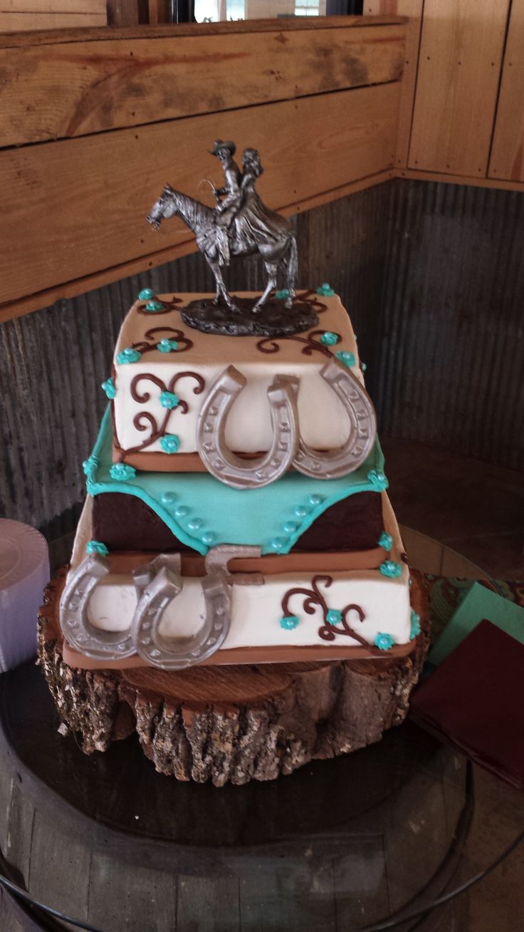 a three tiered cake decorated with horse and horseshoes