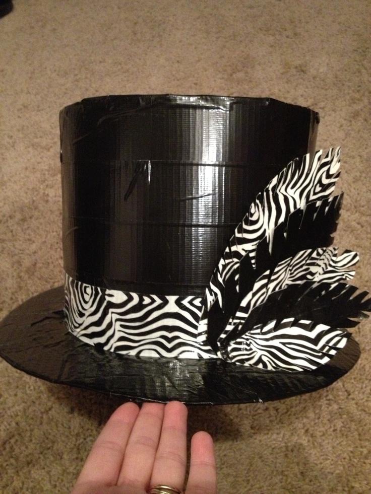 a hand is holding a black and white hat with zebra print on the top,