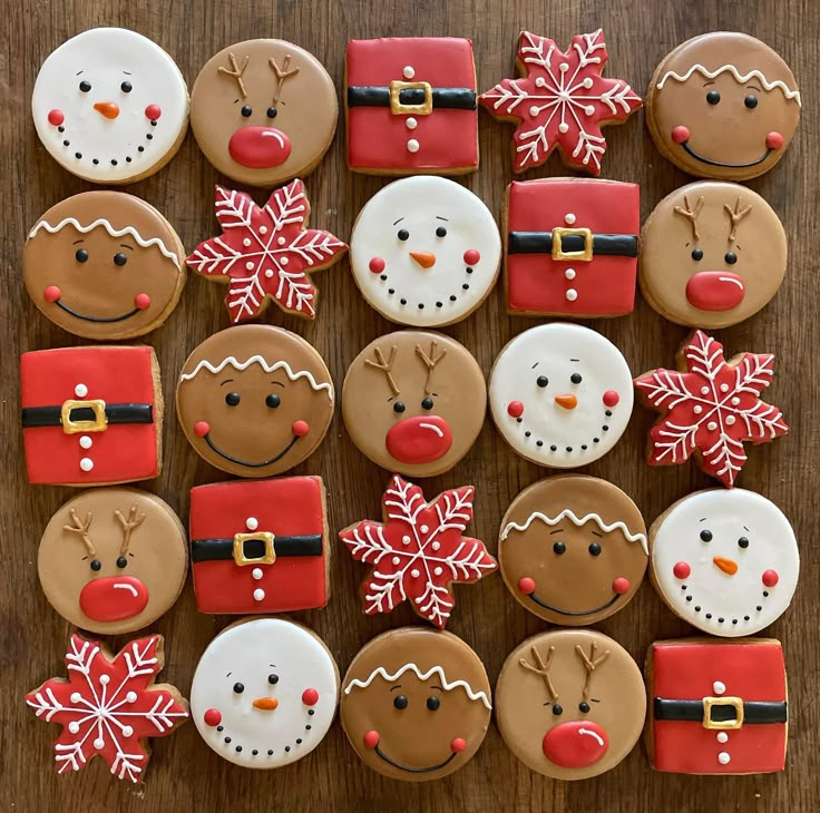 decorated cookies arranged in the shape of santas and snowmen on a wooden table