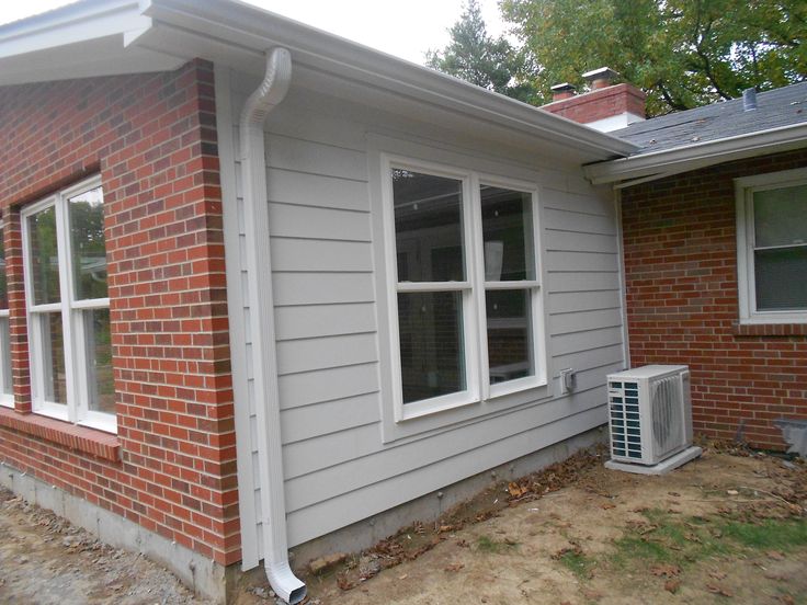 an air conditioner is in front of a brick house that's under construction