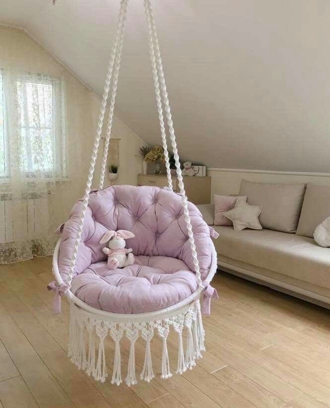 a purple chair hanging from the ceiling in a living room