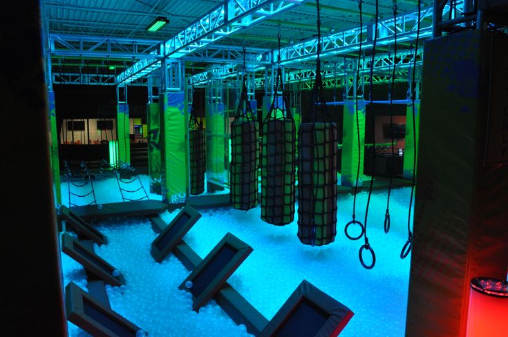 an indoor gym is lit up with blue and green lighting, while other equipment sits on the floor