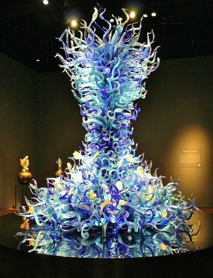 a very tall blue glass sculpture in a room