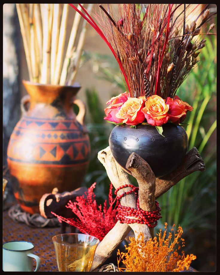 vases with flowers and plants in them sitting on a table next to other items