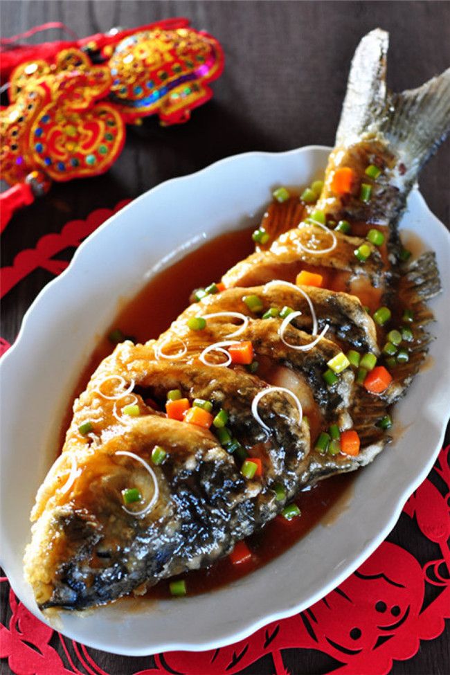 a white plate topped with fish covered in sauce