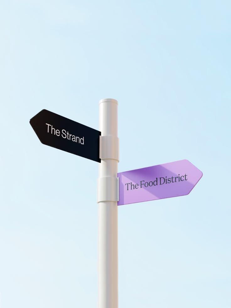 two black and white street signs pointing in opposite directions against a blue sky with no clouds