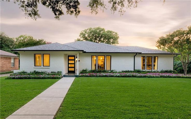 a white house sitting on top of a lush green field