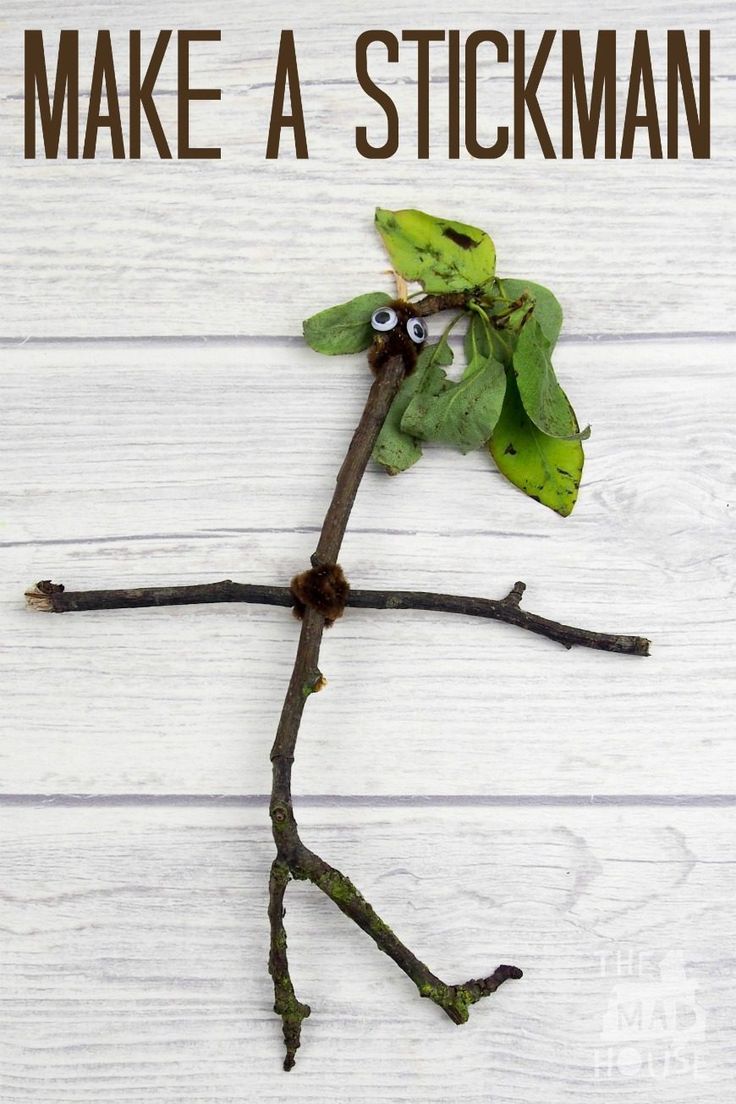 a twig with eyes on it sitting on top of a white wooden floor next to a plant