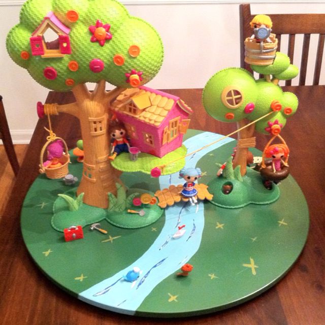 a wooden table topped with lots of toy figurines on top of green plates