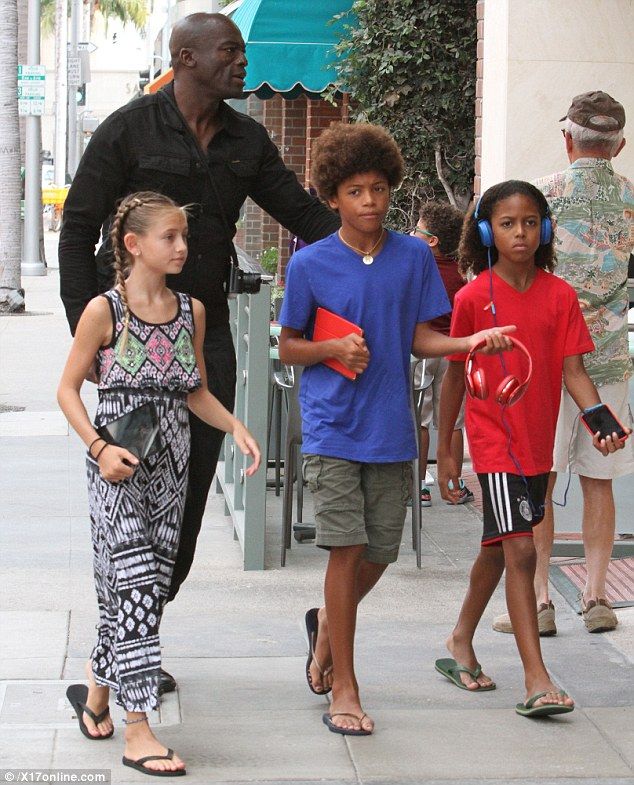 a group of people walking down the street with one person holding his hand out to someone else