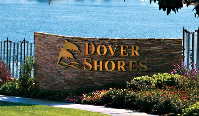 there is a sign that says dover shores in front of some water and trees