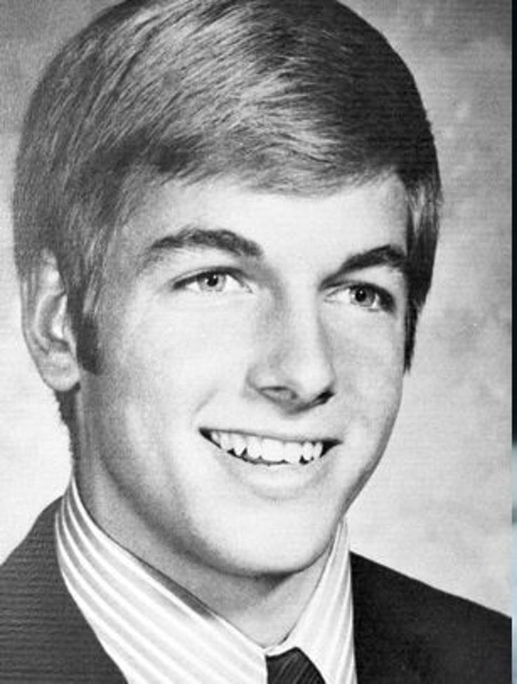 an old photo of a young man in a suit and tie smiling at the camera