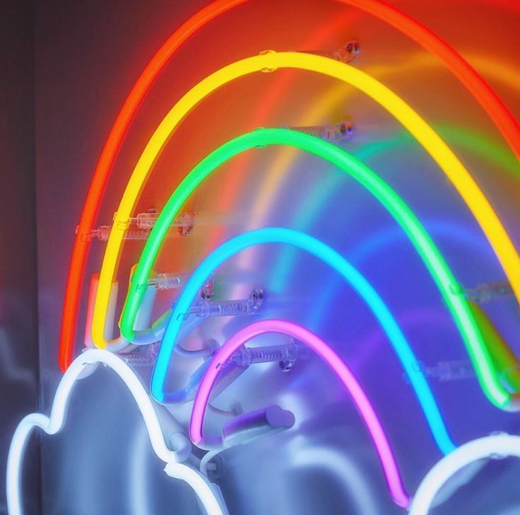 neon lights in the shape of clouds and rainbows against a dark background with white clouds