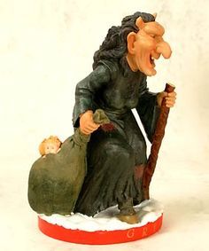 a figurine of a woman holding a bag and a cat sitting on top of it