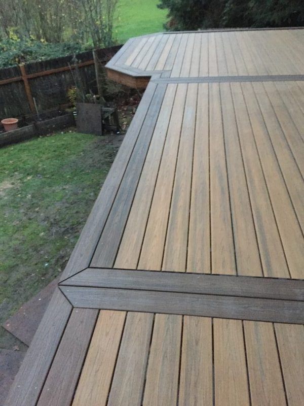 a wooden deck in the middle of a yard