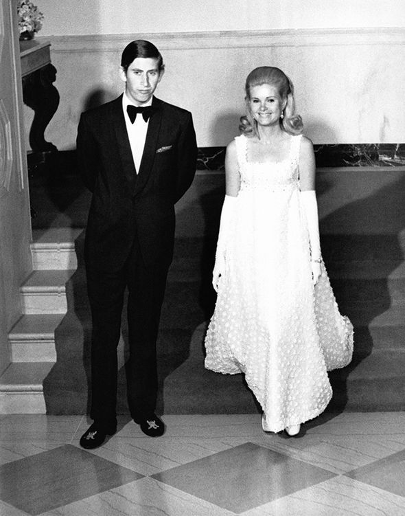 a man in a tuxedo standing next to a woman in a dress