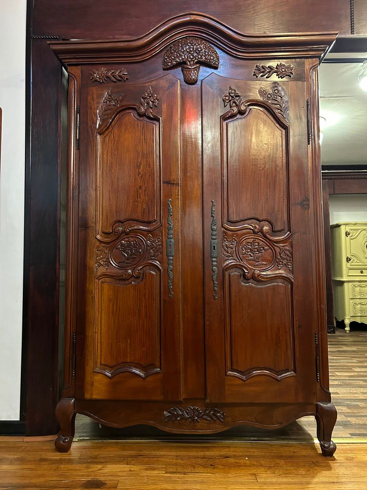 a large wooden armoire sitting on top of a hard wood floor