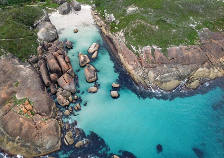 an aerial view of some rocks and water in the middle of a body of water