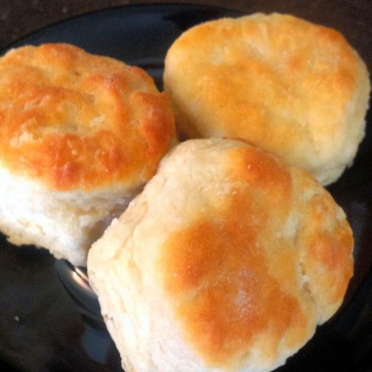 three biscuits sitting on top of a black plate