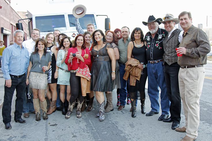 a group of people standing next to each other in front of a truck on the street