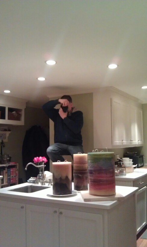 a man sitting on top of a kitchen counter