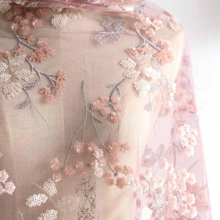 a dress with pink flowers on it and sheer fabric over the top, along with an attached neckline