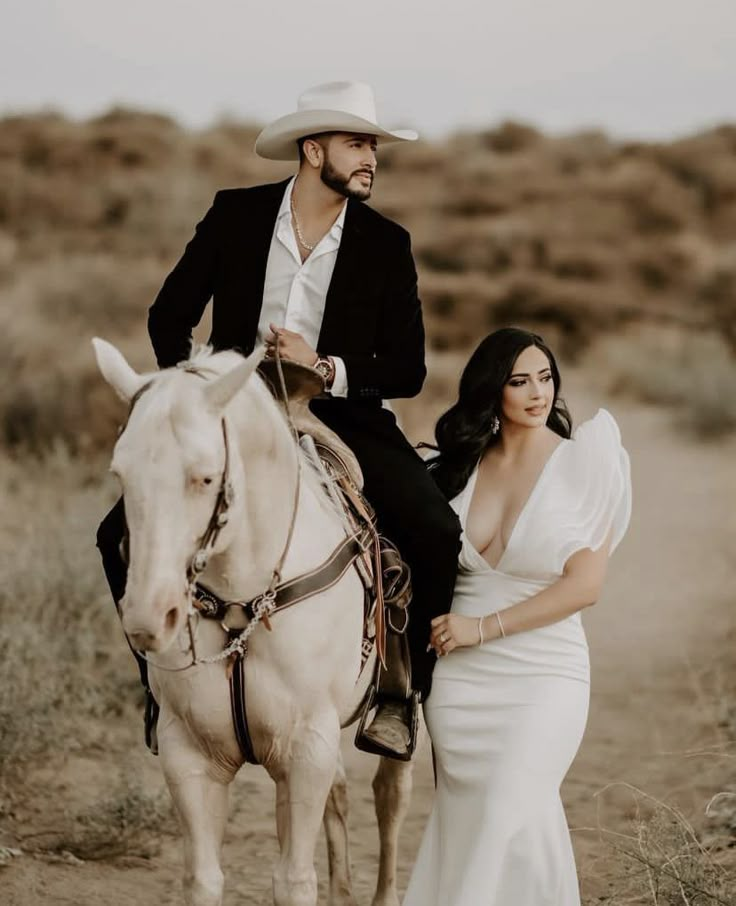 a man riding on the back of a white horse next to a woman in a wedding dress