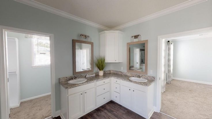 a bathroom with two sinks and mirrors in the middle of it's flooring