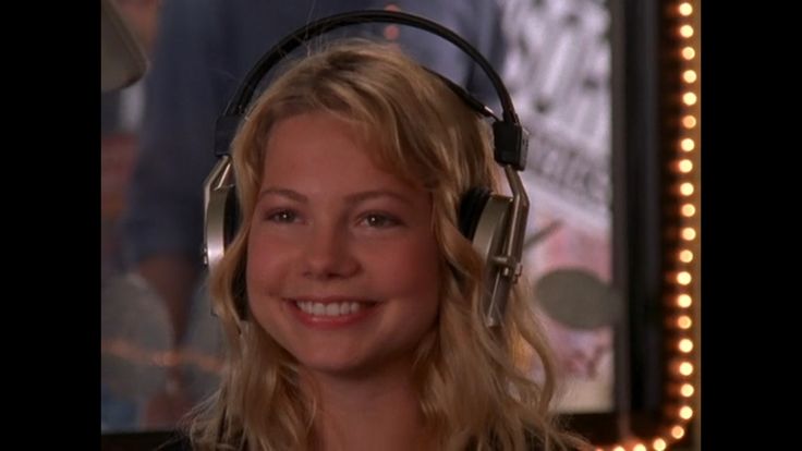 a woman wearing headphones and smiling for the camera