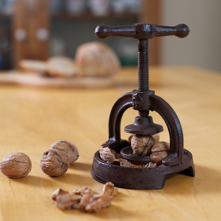 some nuts are sitting on a table next to a clamper and nutcracker