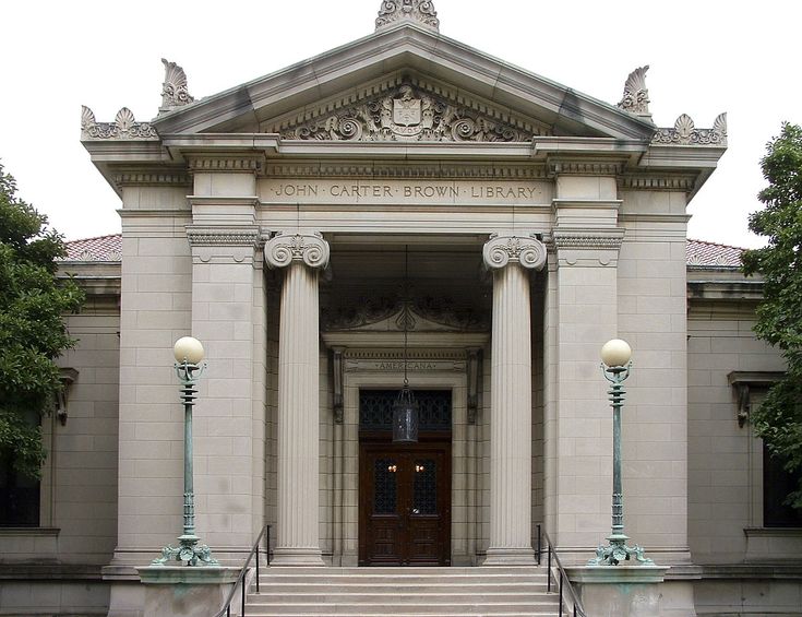 an old building with columns and pillars on the front entrance to it's main entrance