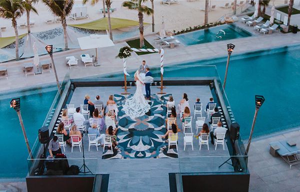 an aerial view of a wedding ceremony at the pool